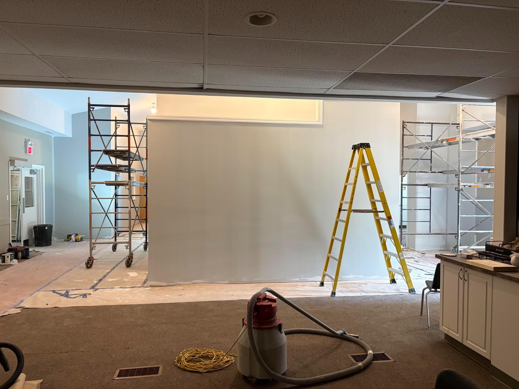 The commons area under construction, with scaffolding and a shop vacuum