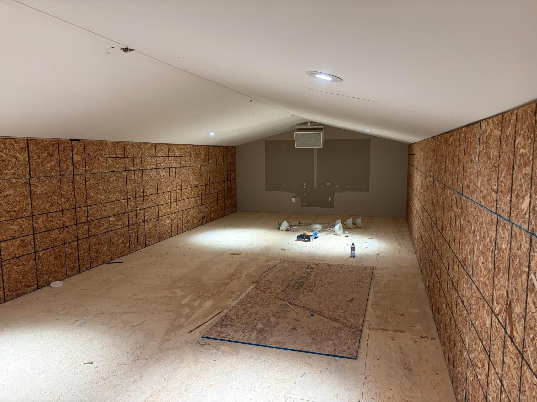 The loft under construction, with bare OSB walls and a plywood subfloor